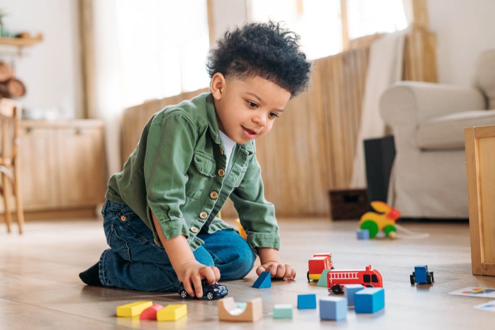 Concentrated little african american boy playing toys